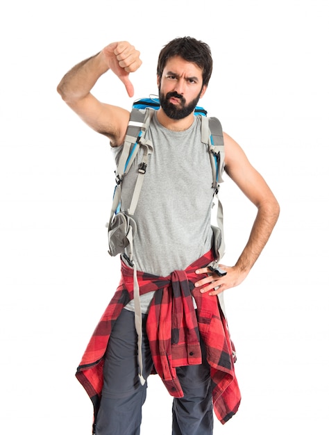 Free photo backpacker doing a bad signal over white background