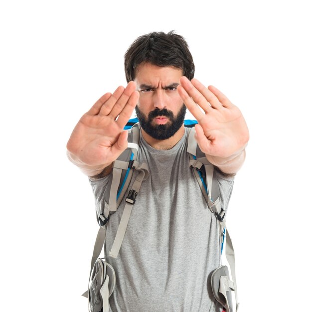 Free photo backpacker making stop sign over white background