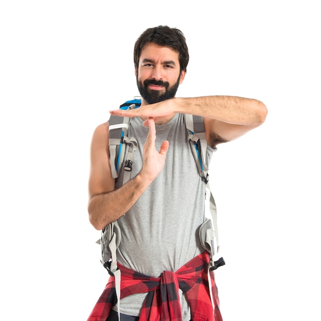 Backpacker making time out gesture over white background