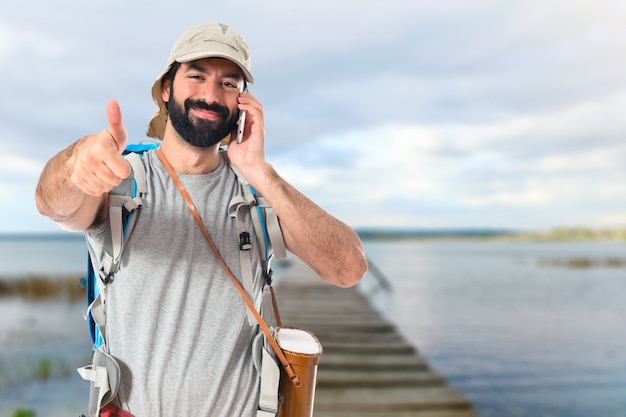 Бесплатное фото backpacker говорить с мобильным на белом фоне