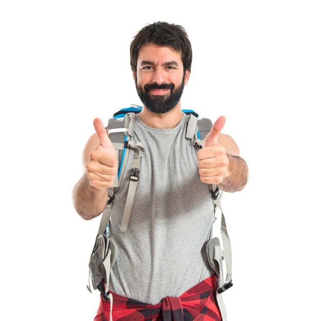 Backpacker with thumb up over white background