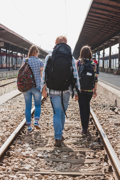 Foto gratuita backpackers che camminano sulle piste del treno