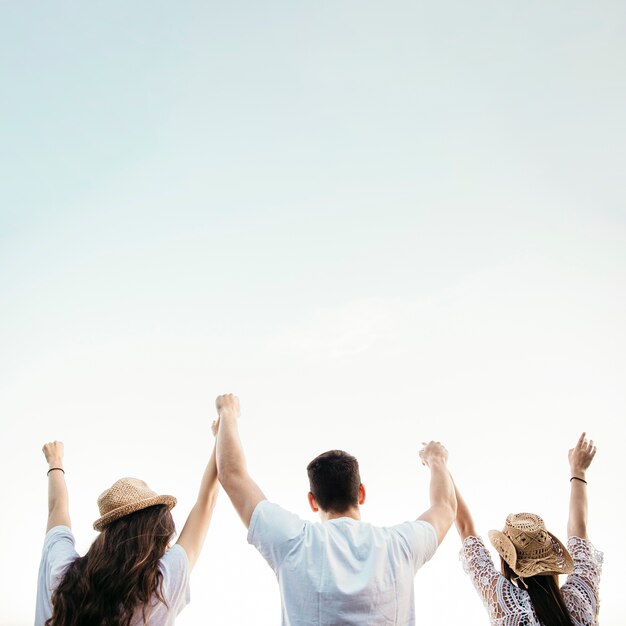 Free Photo backview of friends at the beach with sky background