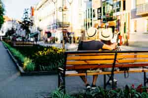 Free photo backview of tourist couple on bench