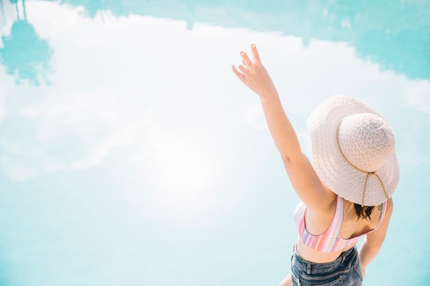 Backview of woman posing in front of pool