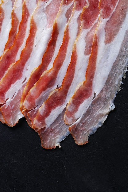 Bacon on black stone plate, top view