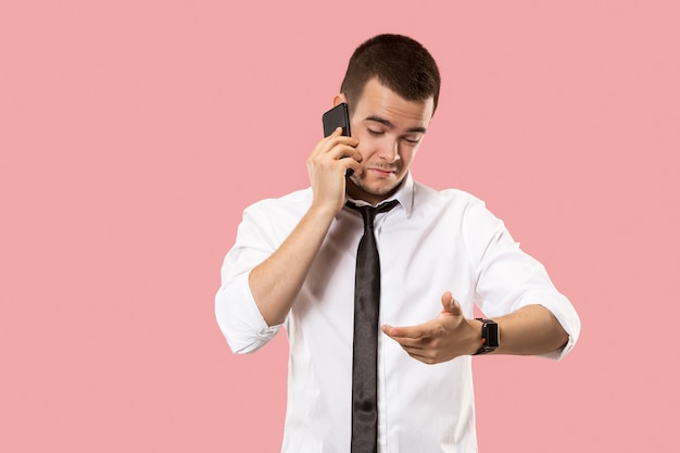 Bad news. Handsome businessman with mobile phone. young business man standing isolated on pink