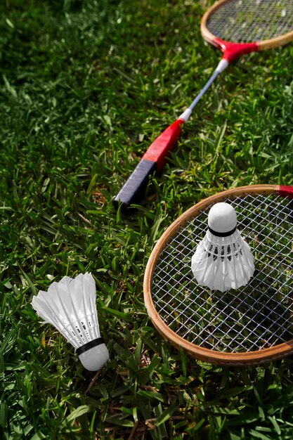 Badminton shuttlecocks and racket on grass high angle