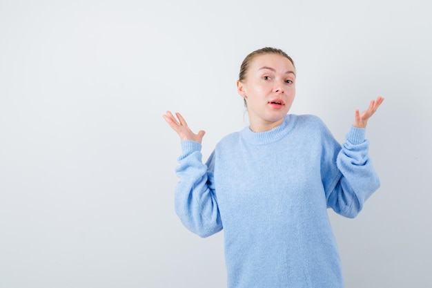 Baffled girl is looking at camera on white background