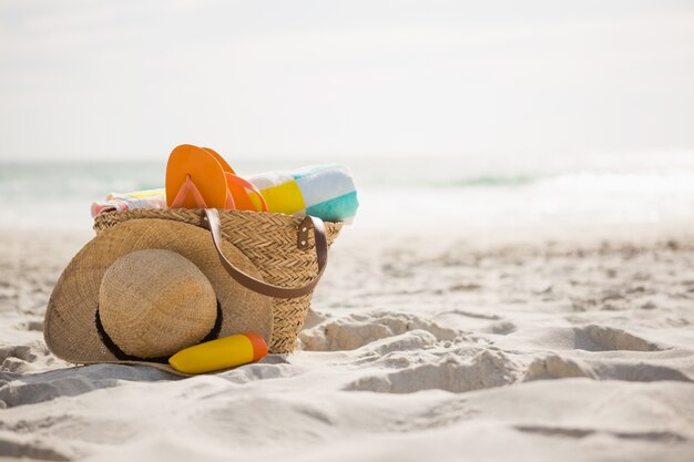 Bag with beach accessories kept on sand