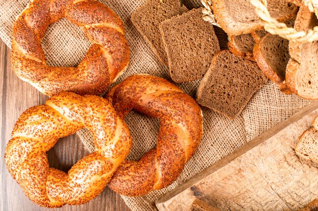 Bagels and slices of bread in basket and on tablecloth