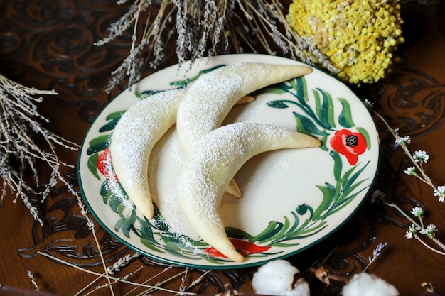 Vista laterale della polvere dello zucchero della pasta delle noci dei bagel