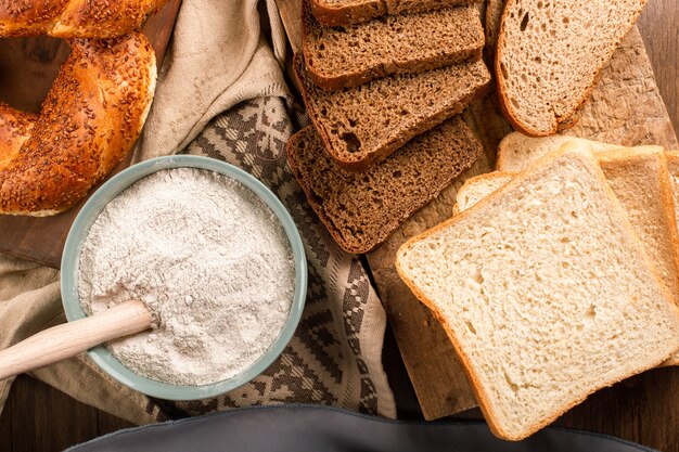 パンのスライスと小麦粉のボウルとベーグル