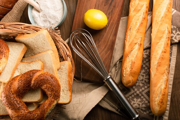 Baguette and bagels in basket with lemon and flour