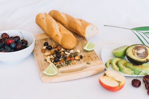 Baguette bread; dry fruits and fruits on white background