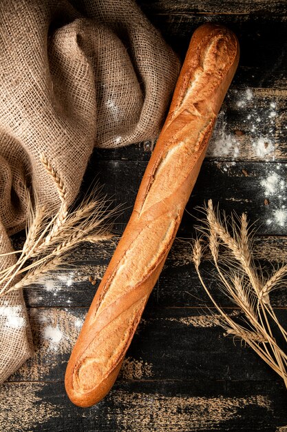 baguette bread with flour and wheat on table