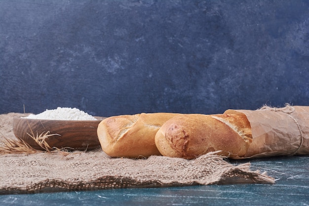 Baguette breads on blue table.