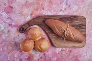 Foto gratuita baguette e focacce su una tavola di legno.