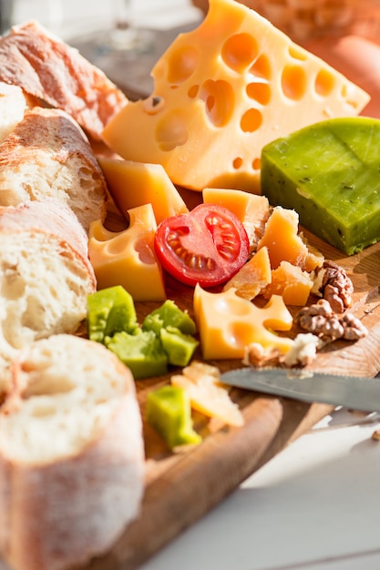 Free photo the baguette and cheese on wooden table