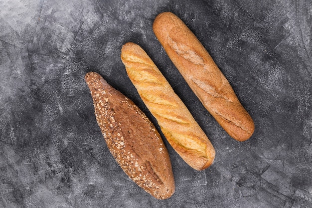 Baguette and loaf on weathered backdrop