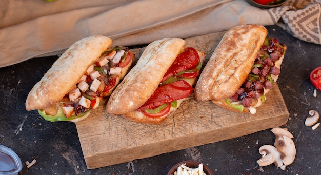 Baguette sandwiches with chicken, meat, sausage and vegetables, top view