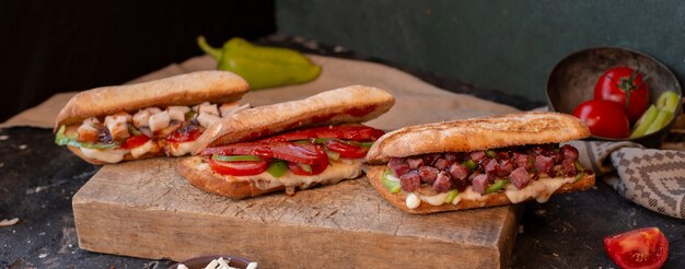 Baguette sandwiches with chicken, meat, sausage and vegetables