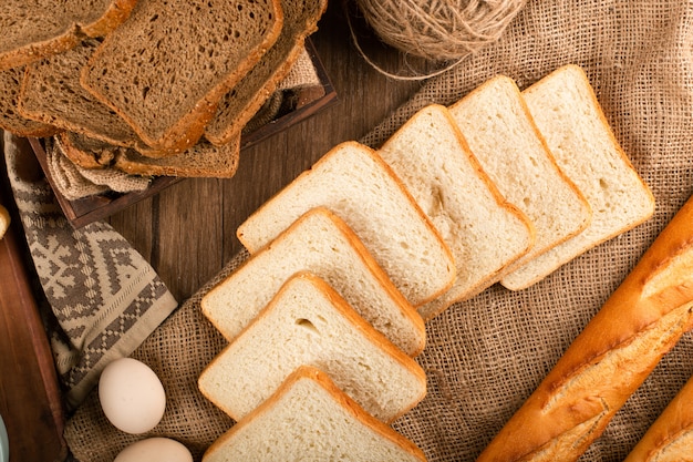 Free photo baguette with slices of brown and white bread