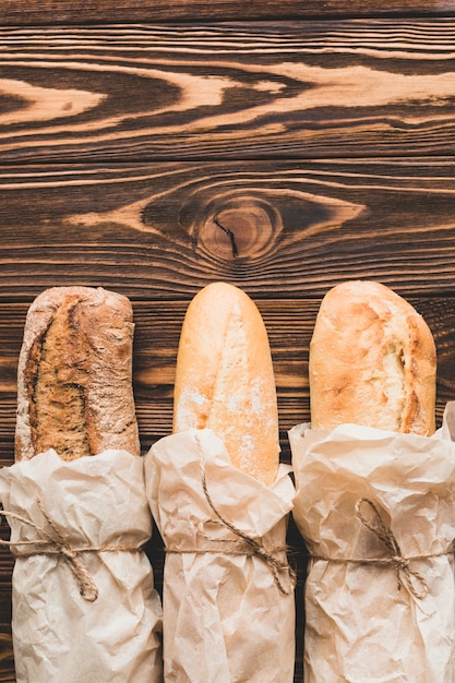 Baguettes in parchment on wooden table