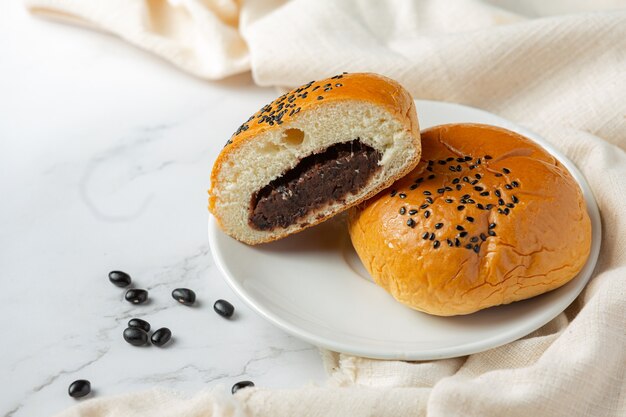 白いボウルに置いた焼き黒豆のペーストパン