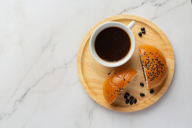 커피와 함께 제공되는 나무 접시에 구운 검은 콩 페이스트 빵