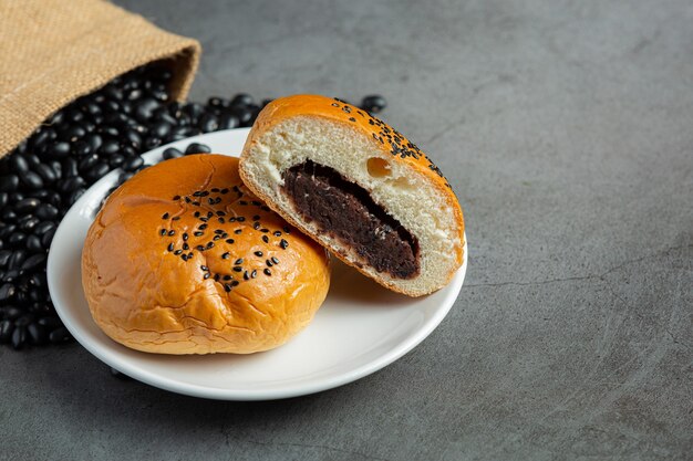 白い皿に黒豆のペーストパンを焼いた