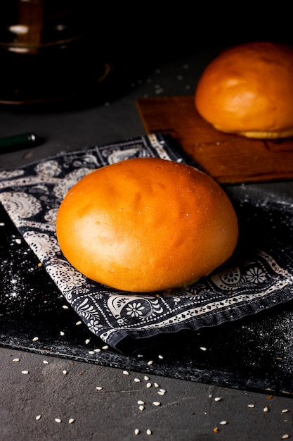 Free photo baked bread bun placed on piece of fabric