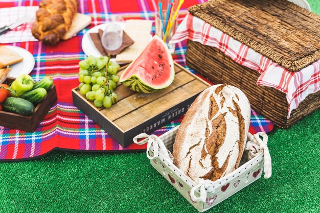 Baked bread; fruits and picnic basket on turf