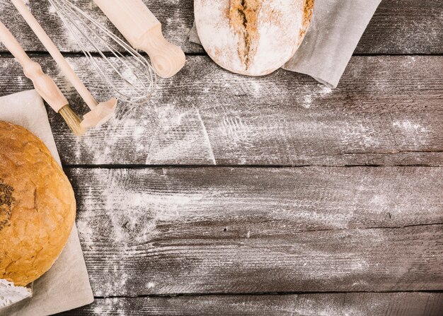 Baked bread and kitchen equipments on plank