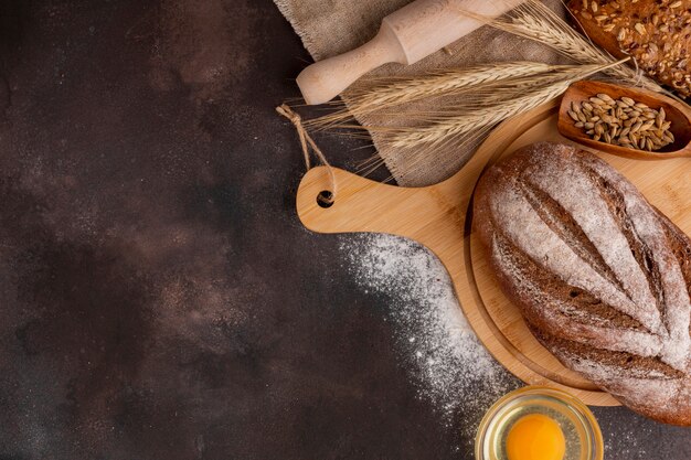 Baked bread on wooden board and wheat grass