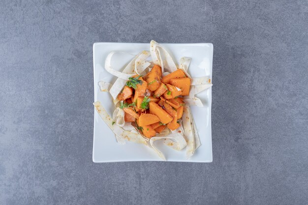 Baked carrots with slice lavash in bowl , on the marble surface.