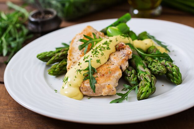 Baked chicken garnished with asparagus and herbs