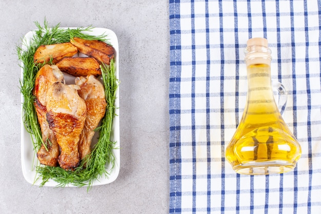 Baked chicken legs with greens on a white plate