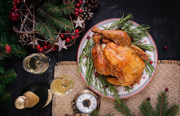 焼き鳥または七面鳥。クリスマステーブルには、明るい見掛け倒しで飾られた七面鳥が添えられています。フライドチキン、テーブル。クリスマスディナー。テーブルセッティング。上面図、上