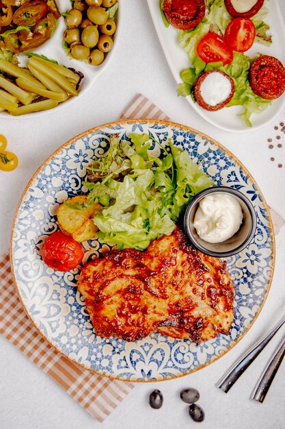 baked chicken with cheese grilled potatoes and tomatoes