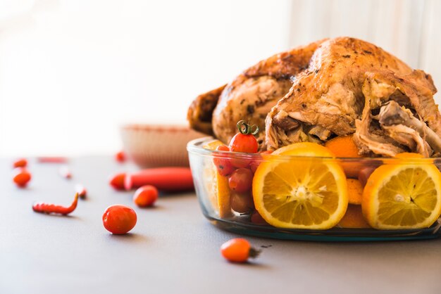 Baked chicken with oranges in glassware