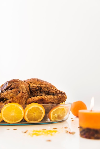 Free photo baked chicken with oranges on white table