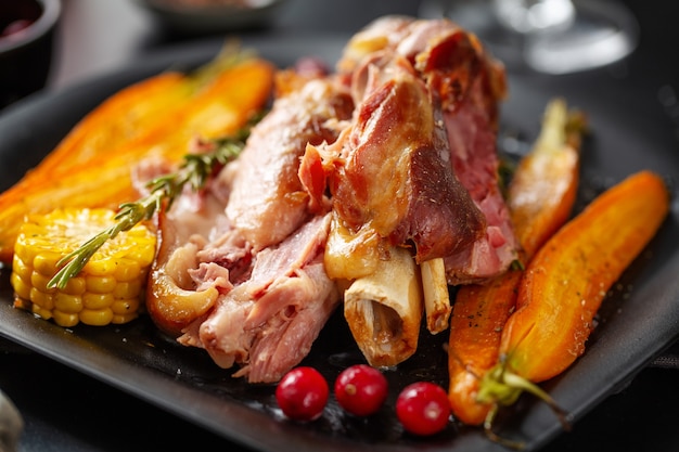 접시에 야채와 향신료와 구운된 크리스마스 돼지고기. 확대