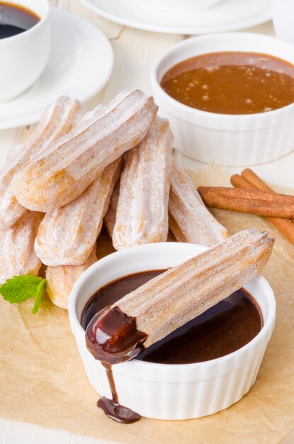 Baked churros with cinnamon  powdered sugar  chocolate and caramel sauce. spanish cuisine.