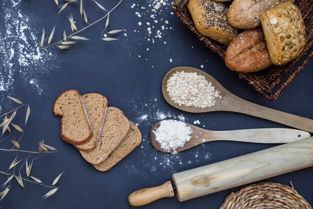 Baked food, rolling pin with spoon of flour and oat on kitchen worktop