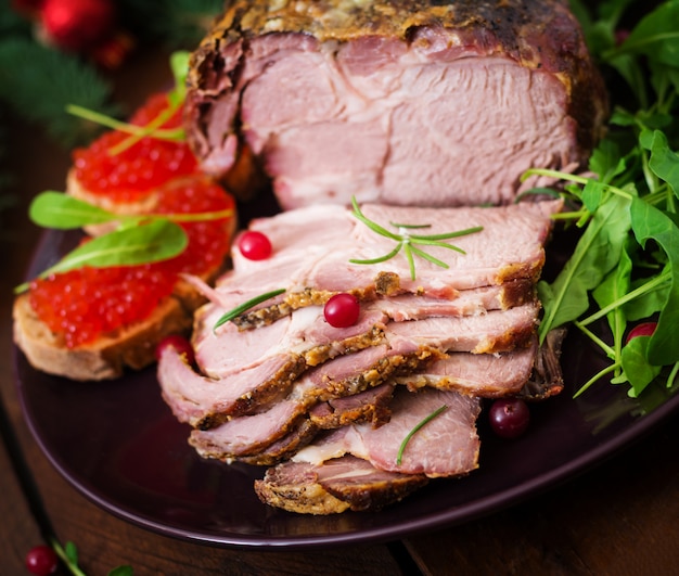 Free photo baked ham and red caviar, served on old wooden table.