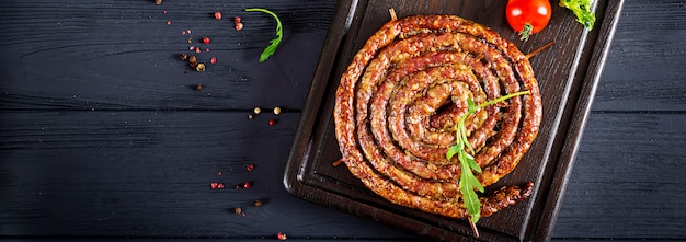 Baked homemade sausage on a wooden board.