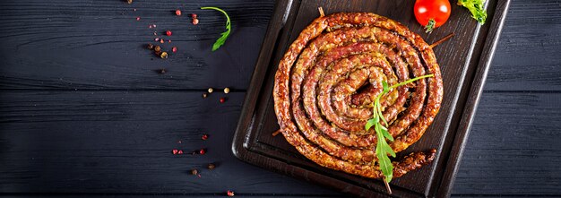 Baked homemade sausage on a wooden board.