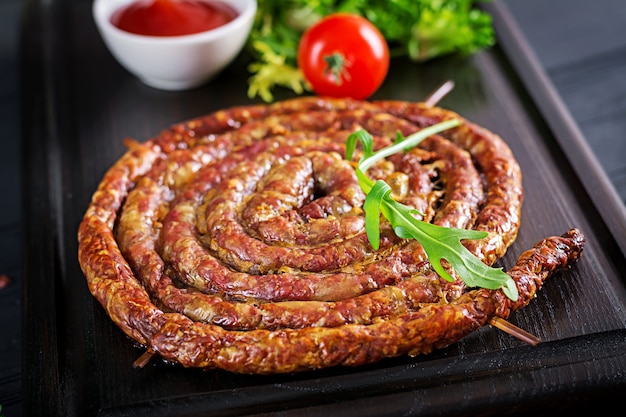 Foto gratuita salsiccia fatta in casa al forno su una tavola di legno.