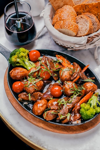 Baked meat with vegetables on a wooden stand